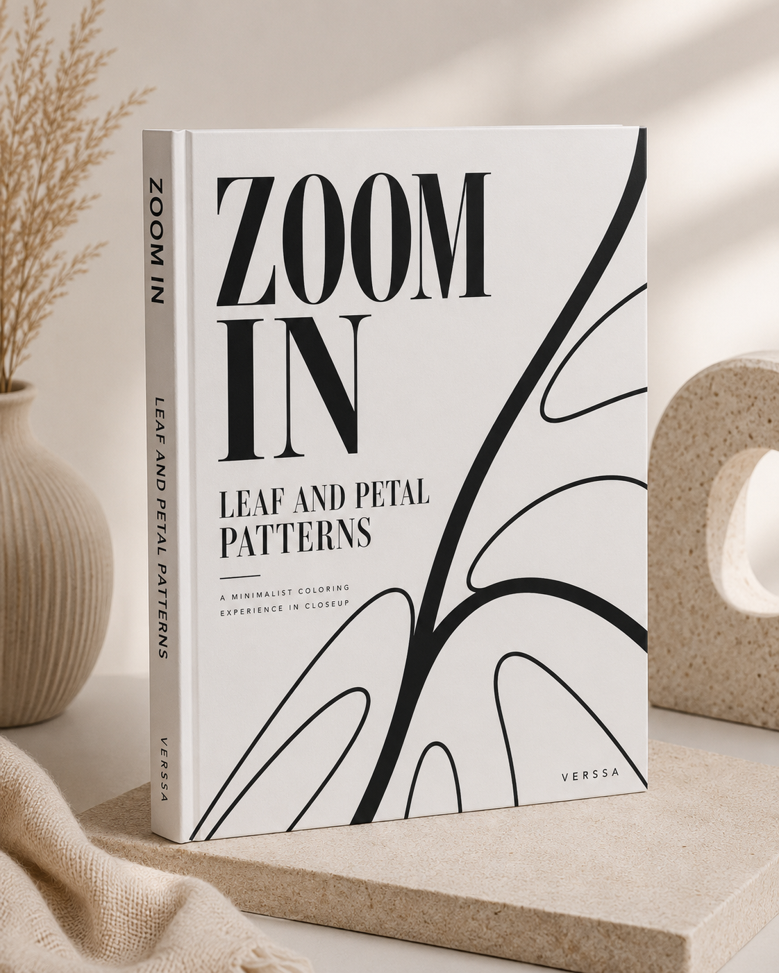 Zoom In: Leaf & Petal Patterns ebook cover displayed on a stone pedestal beside dried pampas grass